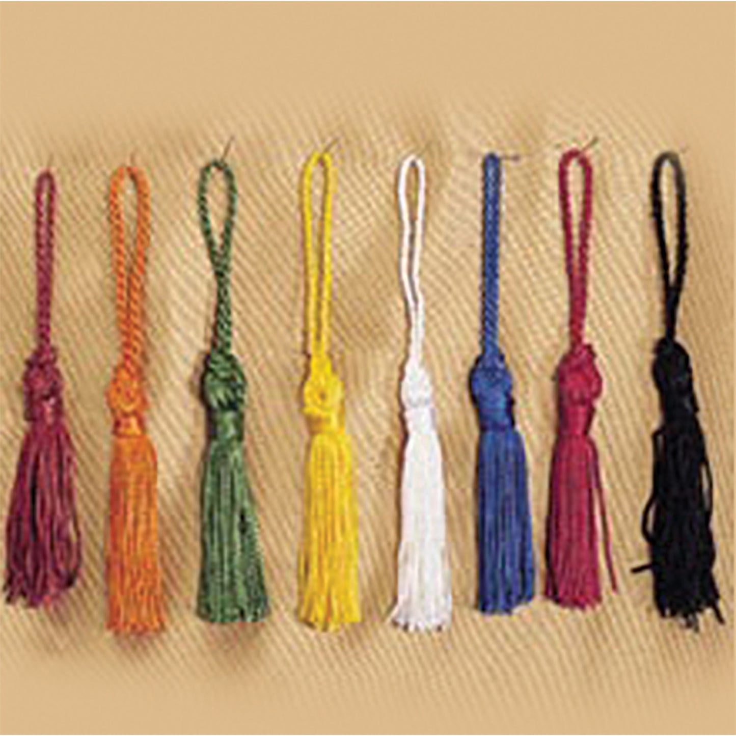 Color-coordinated tassels for majorette boots in red, royal blue, gold, black, maroon, orange, kelly, and white polyester strands with satin finish, equipped with metal clasp for secure attachment.