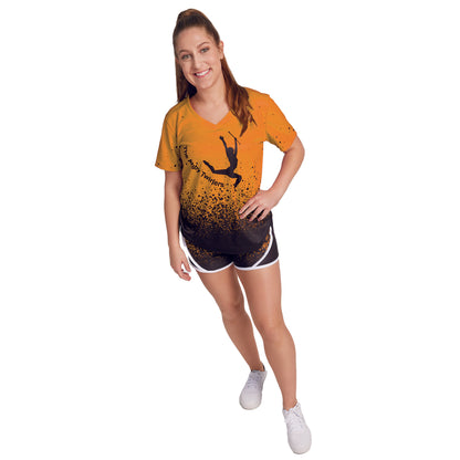 S-Line V-Neck T-Shirt female model wearing an orange and black v-neck t-shirt with a graphic of a female gymnast on it, paired with black shorts and white shoes.