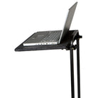 Mobile Harmony Station laptop shelf mounted beneath performance cart top, featuring black steel shelf surface with safety lip, supporting a keyboard and amp below—designed for marching band field use with caster mobility.